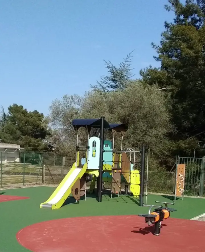 Aire de jeux extérieure avec revêtement en sol souple et structures pour enfants